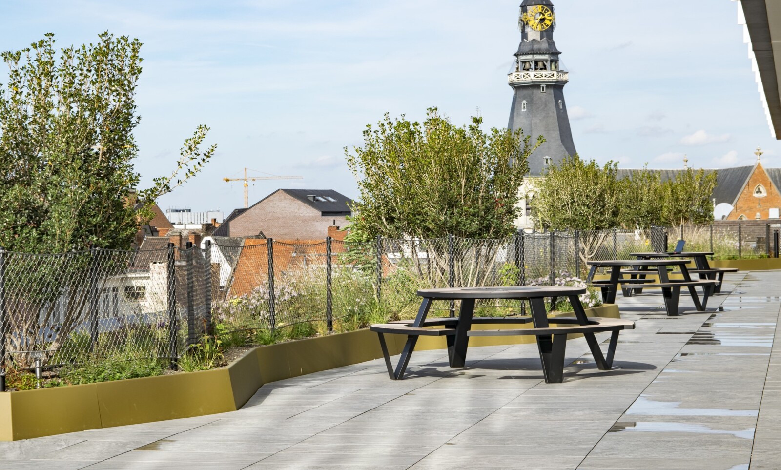 Terrasse sur le toit avec deux tables de pique-nique rondes