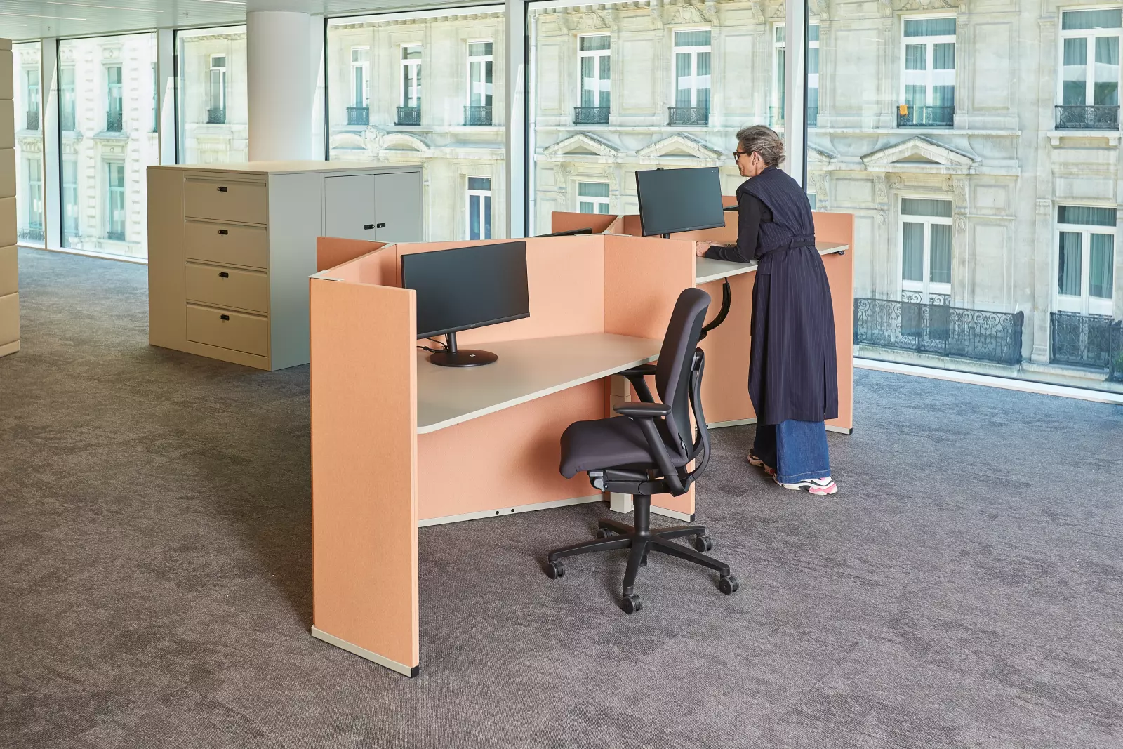 Espace de bureau moderne avec des postes de travail réglables et ergonomiques dans un environnement ouvert.