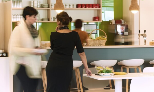 Cafetaria met 2 vrouwen die staan de praten met elkaar