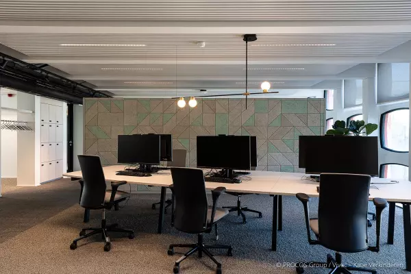 Grande table avec écrans et chaises de bureau ergonomiques