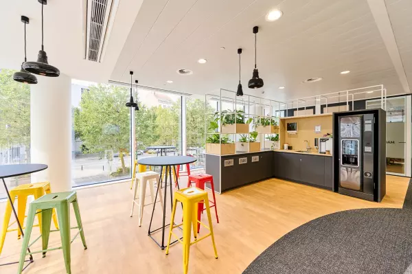 Customised coffee corner with high tables and colourful bar stools