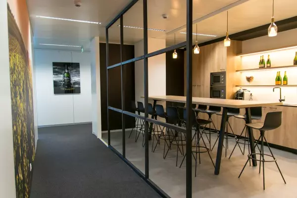Coffee corner with high wooden table and black bar stools