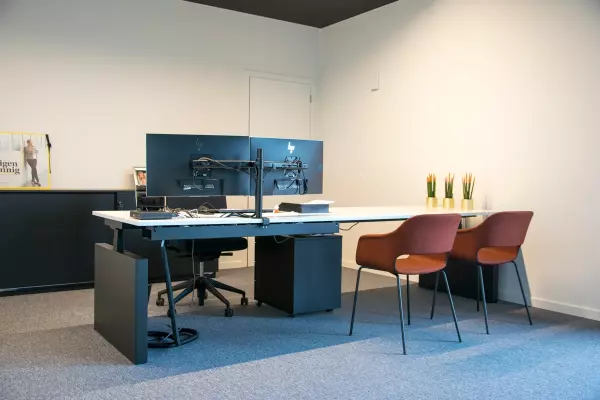 Bureau assis-debout avec chaises orange pour visiteurs