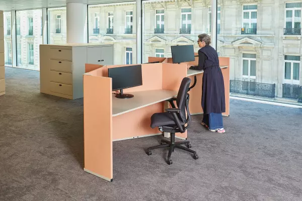 Moderne kantoorruimte met verstelbare, ergonomische werkplekken in een open omgeving. 